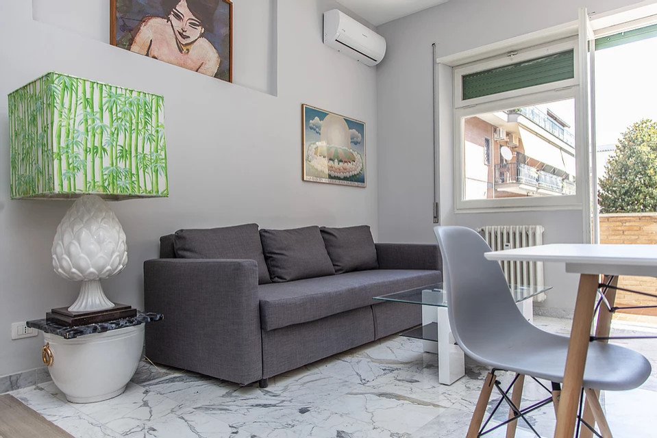 Ispirazione per un piccolo soggiorno design aperto con TV autoportante e pavimento grigio