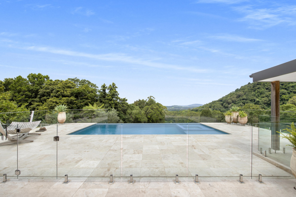 Стильный дизайн: большой прямоугольный бассейн на заднем дворе в современном стиле - последний тренд