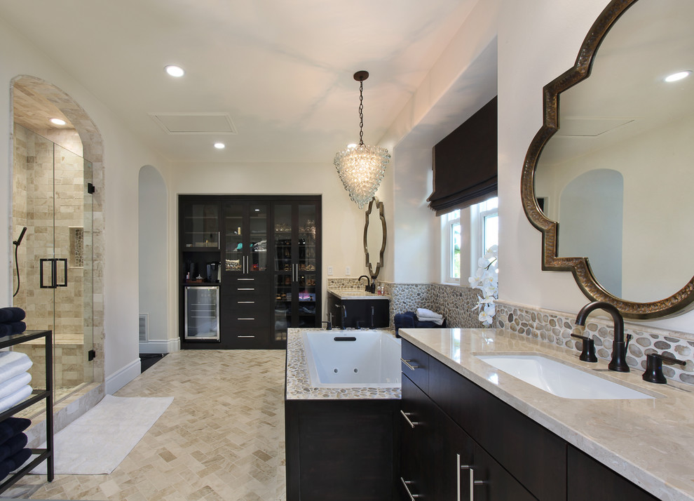 Mid-sized contemporary master bathroom in Orange County with flat-panel cabinets, black cabinets, a drop-in tub, an alcove shower, multi-coloured tile, pebble tile, beige walls, ceramic floors, an undermount sink, engineered quartz benchtops, beige floor and a hinged shower door.