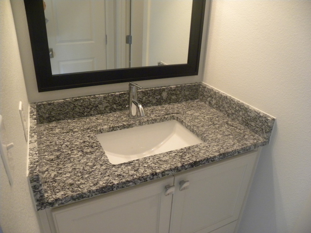 This is an example of a traditional kids bathroom in Dallas with shaker cabinets, grey cabinets, a corner shower, a two-piece toilet, white tile, porcelain tile, grey walls, porcelain floors, an undermount sink and granite benchtops.