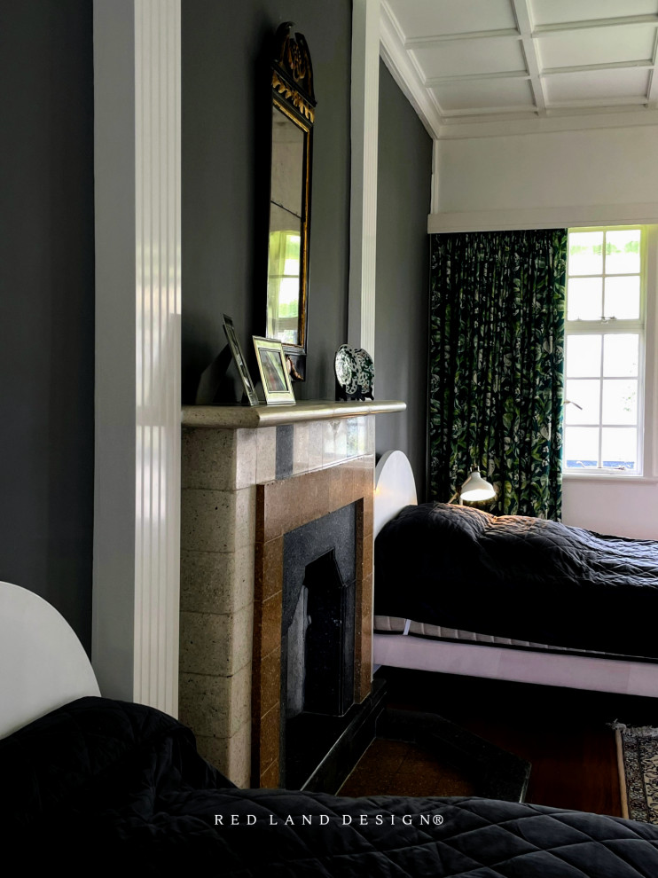 На фото: гостевая спальня среднего размера, (комната для гостей) в викторианском стиле с серыми стенами, темным паркетным полом, стандартным камином, фасадом камина из камня, коричневым полом, кессонным потолком и кирпичными стенами