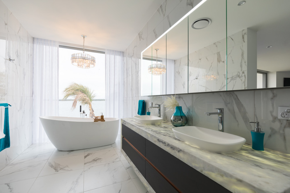 Design ideas for a contemporary bathroom in Gold Coast - Tweed with a freestanding tub, white tile, white walls, marble benchtops, black floor, a double vanity and a floating vanity.