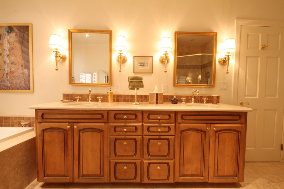 Design ideas for a mid-sized traditional master bathroom in Los Angeles with an undermount sink, raised-panel cabinets, medium wood cabinets, marble benchtops, a drop-in tub, a corner shower, a one-piece toilet, beige tile, ceramic tile, beige walls and travertine floors.