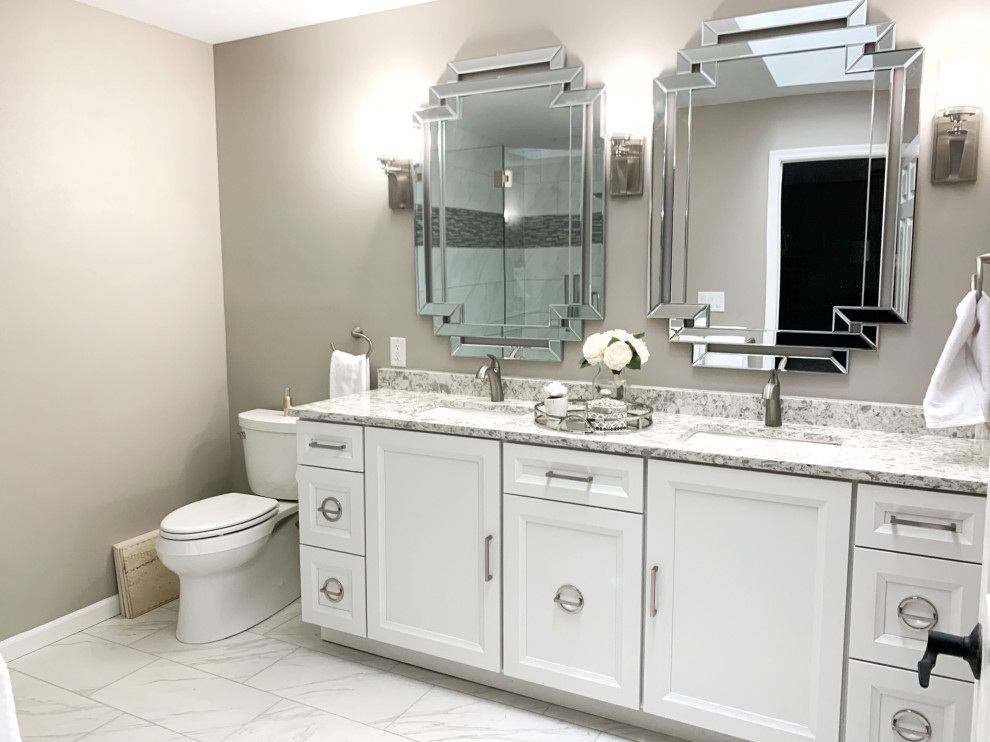 Photo of a medium sized classic ensuite bathroom in Milwaukee with recessed-panel cabinets, white cabinets, a two-piece toilet, grey walls, a submerged sink, white floors, multi-coloured worktops, double sinks and a built in vanity unit.