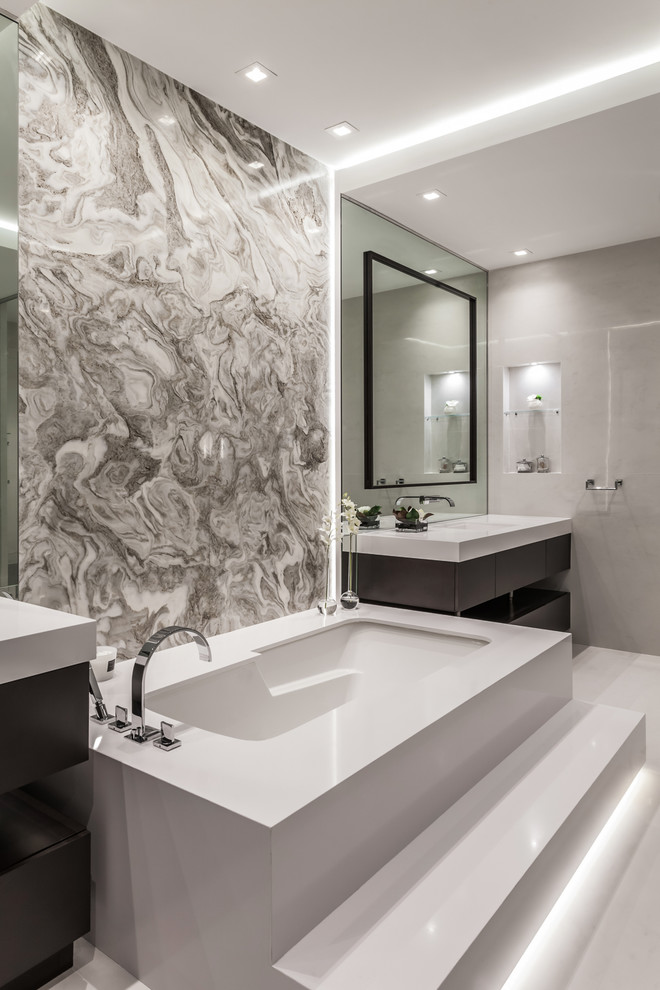Design ideas for a large contemporary master wet room bathroom in Miami with flat-panel cabinets, dark wood cabinets, an undermount tub, a one-piece toilet, beige tile, ceramic tile, beige walls, cement tiles, an integrated sink, beige floor and white benchtops.