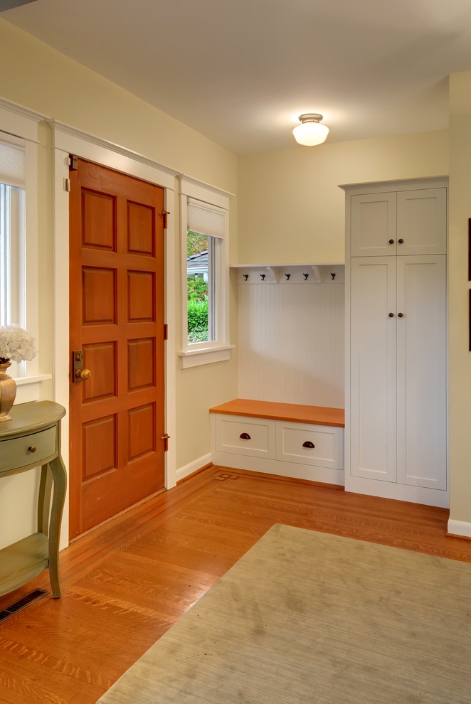 Design ideas for an arts and crafts entryway in Seattle with beige walls, medium hardwood floors and a medium wood front door.