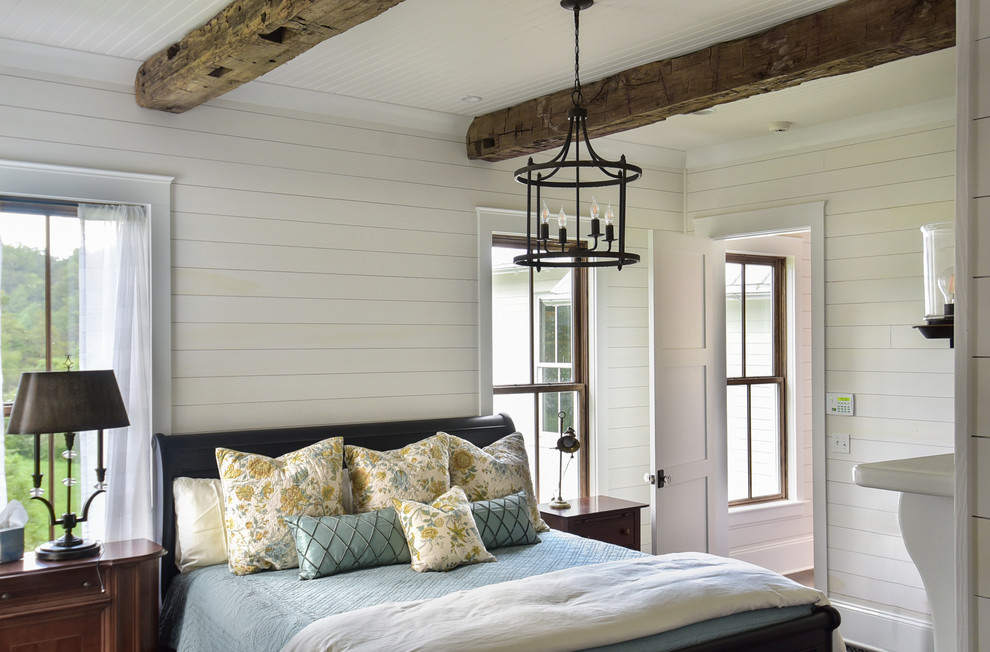 Design ideas for a country master bedroom in Other with white walls, dark hardwood floors, a standard fireplace, a wood fireplace surround and brown floor.