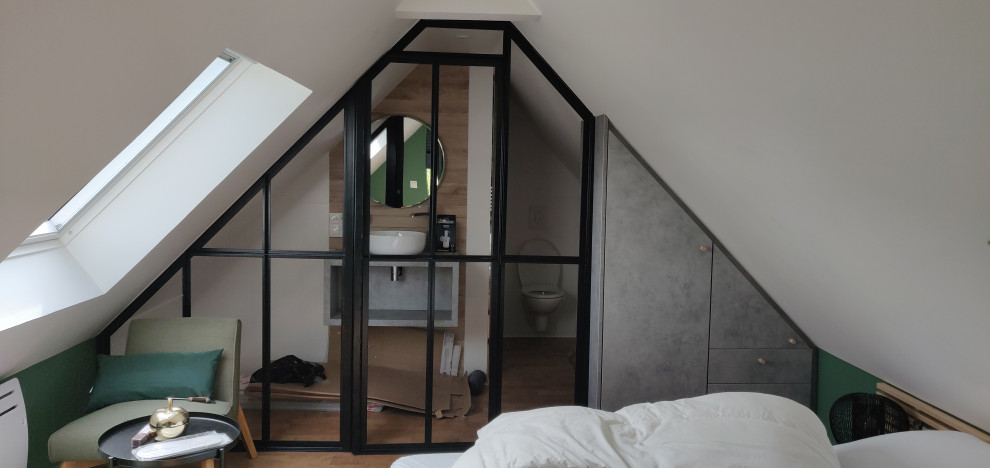 Esempio di una piccola camera da letto stile loft industriale con pareti bianche, pavimento in sughero e nessun camino