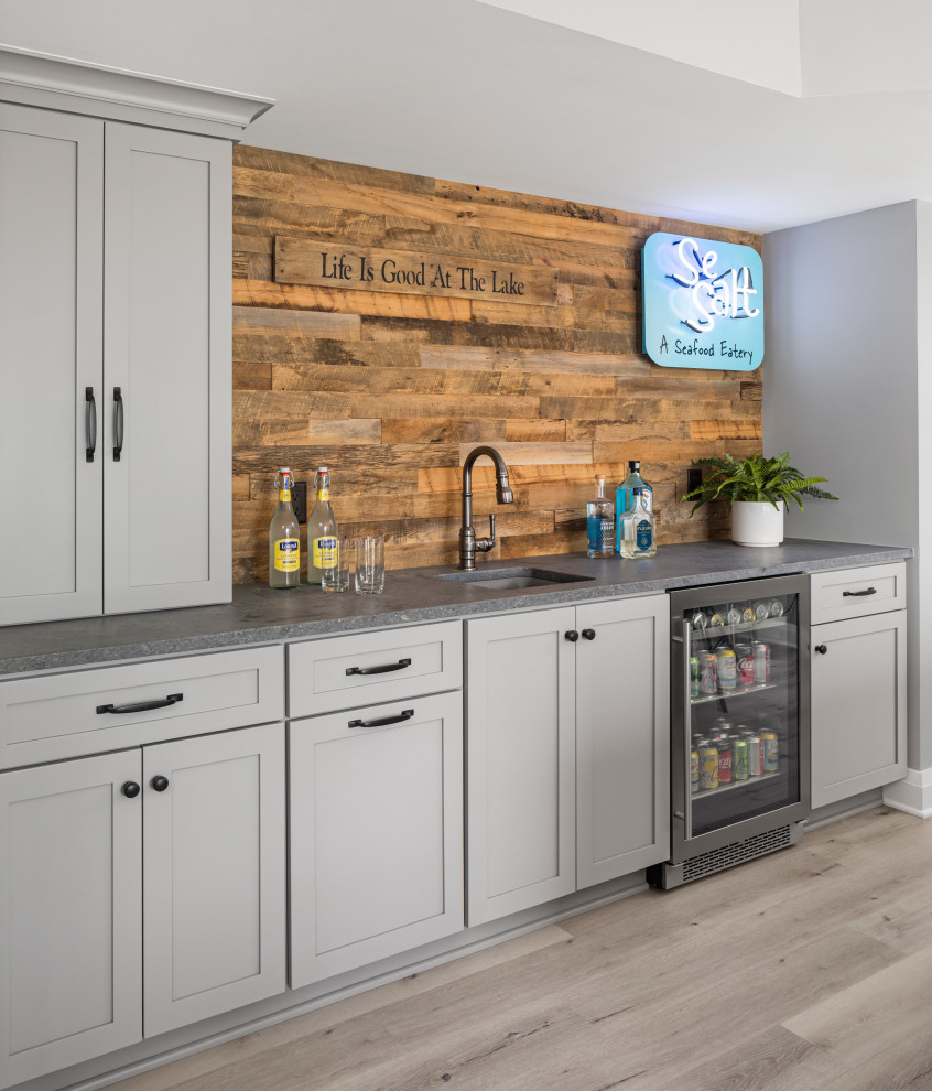 Photo of a beach style single-wall wet bar in Minneapolis with an undermount sink, shaker cabinets, grey cabinets, brown splashback, timber splashback, grey floor and grey benchtop.