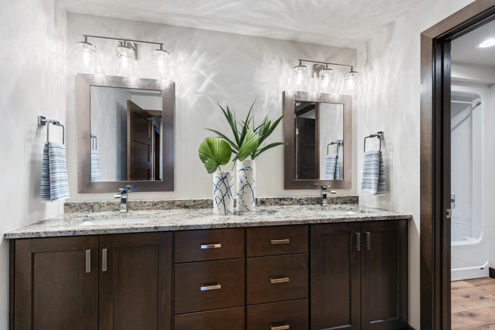 Mid-sized transitional kids' porcelain tile, brown floor and double-sink alcove bathtub photo with shaker cabinets, brown cabinets, a two-piece toilet, white walls, an undermount sink, granite countertops, multicolored countertops and a built-in vanity