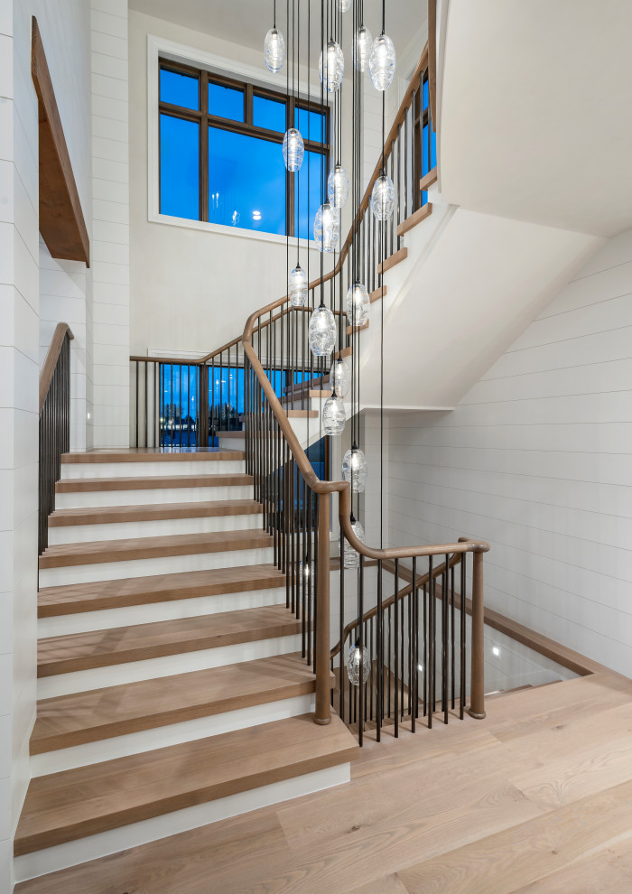 Photo of an expansive country wood curved staircase in Salt Lake City with wood risers and wood railing.