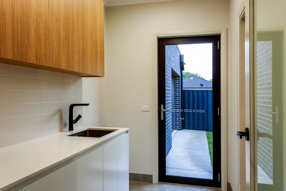 This is an example of a modern laundry room in Other.