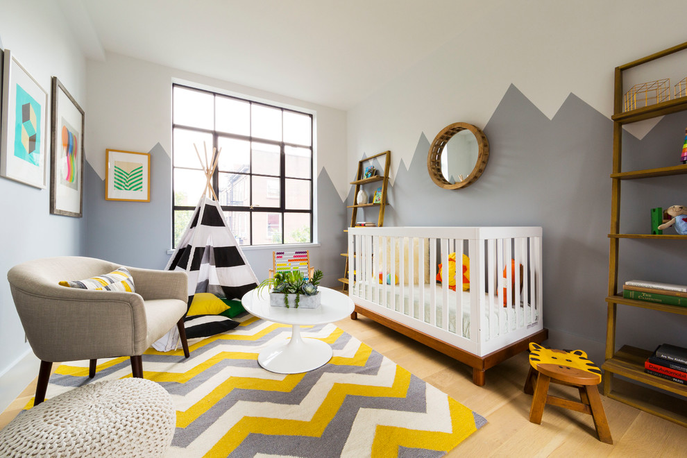 Design ideas for a small contemporary gender-neutral nursery in New York with grey walls, light hardwood floors and beige floor.