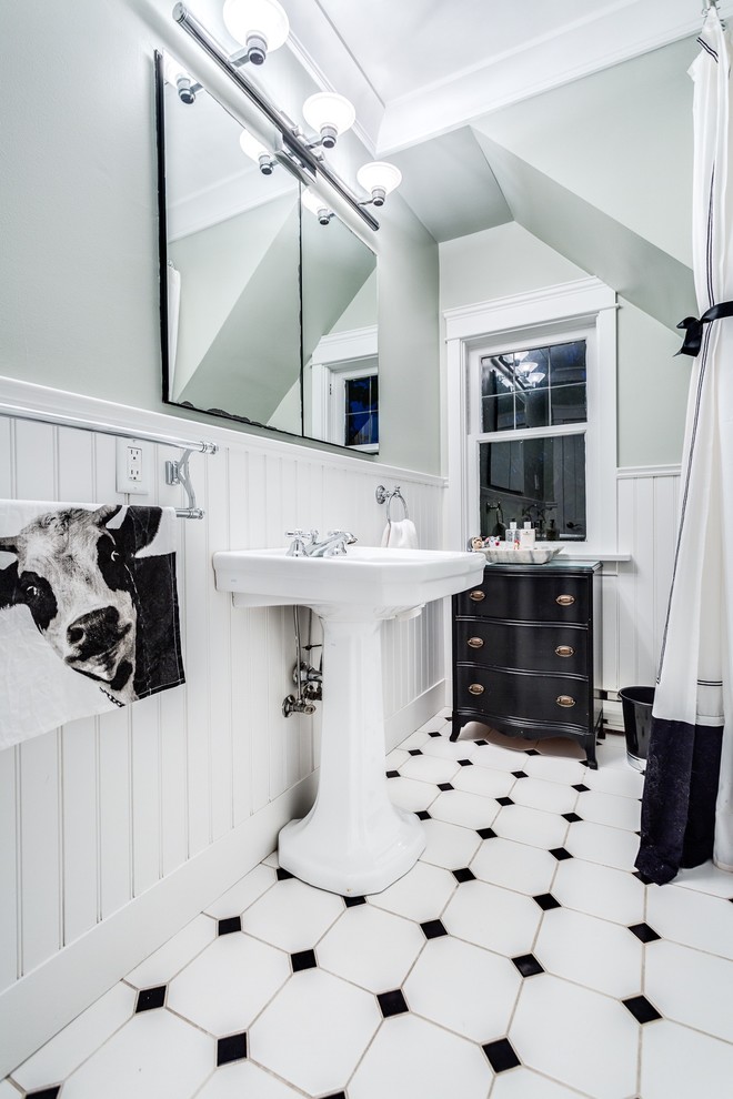 This is an example of a mid-sized traditional 3/4 bathroom in Vancouver with flat-panel cabinets, black cabinets, an alcove tub, an alcove shower, a one-piece toilet, black and white tile, porcelain tile, white walls, porcelain floors and a pedestal sink.