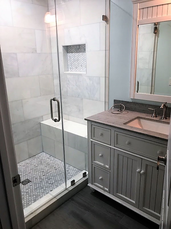 Small modern 3/4 bathroom in Los Angeles with recessed-panel cabinets, white cabinets, an alcove shower, a two-piece toilet, gray tile, multi-coloured tile, white tile, porcelain tile, blue walls, porcelain floors, an undermount sink, quartzite benchtops, grey floor and a hinged shower door.