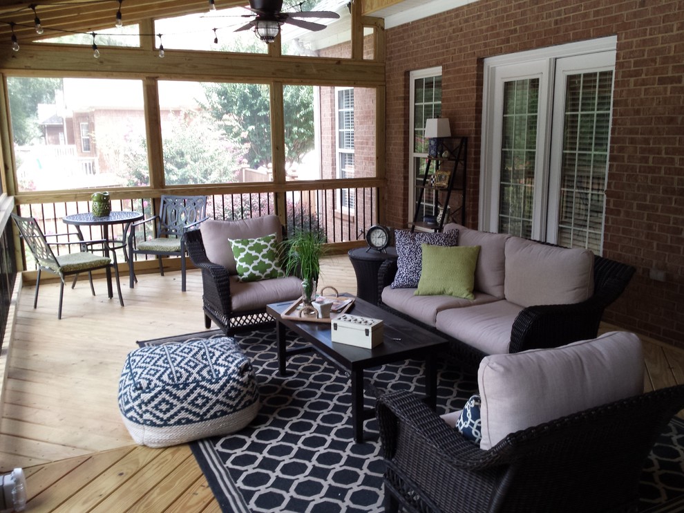 This is an example of a large traditional backyard screened-in verandah in Atlanta with a roof extension.
