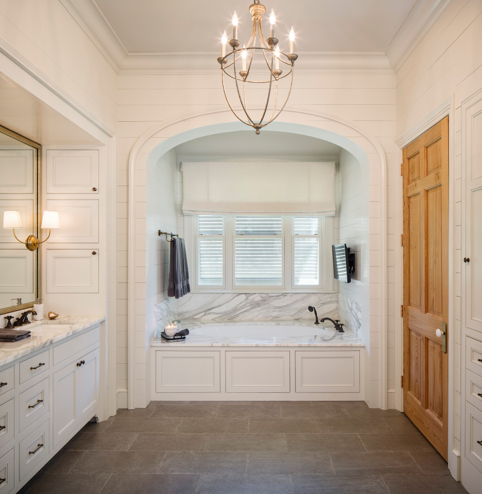 This is an example of a large traditional master bathroom in New Orleans with beaded inset cabinets, white cabinets, an undermount tub, gray tile, white walls, porcelain floors, an undermount sink, grey floor, grey benchtops, a double vanity, a built-in vanity and planked wall panelling.