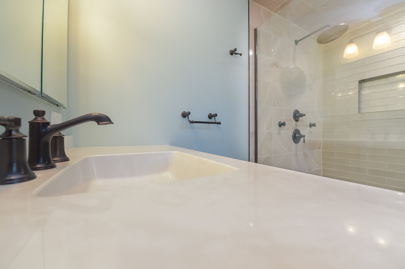 Cette image montre une salle de bain principale design de taille moyenne avec une douche d'angle, une cabine de douche à porte battante, meuble simple vasque et meuble-lavabo encastré.