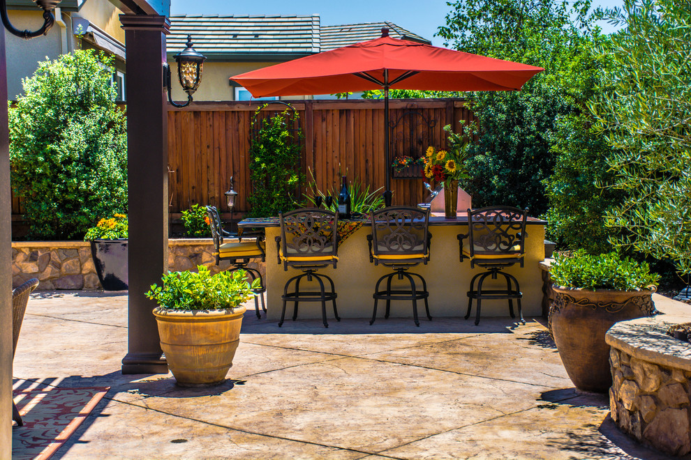 This is an example of a large traditional backyard patio in San Francisco with an outdoor kitchen, concrete pavers and a gazebo/cabana.