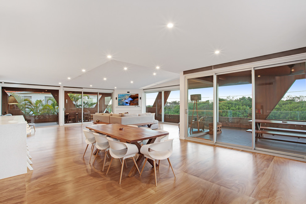 This is an example of a contemporary open plan dining in Sunshine Coast with white walls and medium hardwood floors.