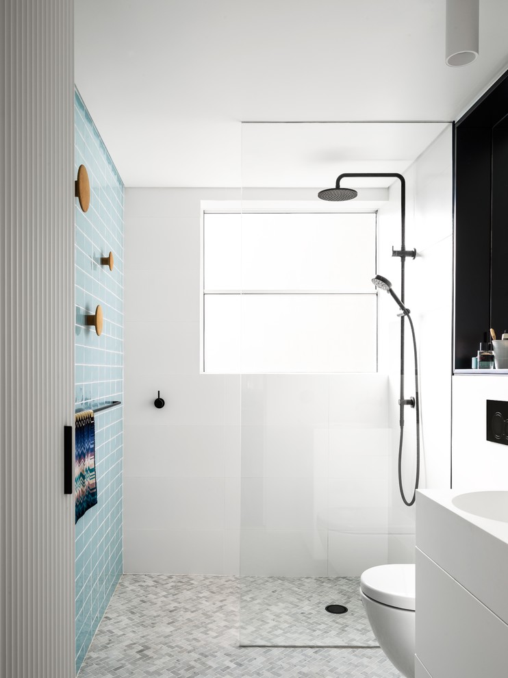 Photo of a small contemporary master bathroom in Sydney with an open shower, a wall-mount toilet, black and white tile, mosaic tile floors, an integrated sink, ceramic tile, white walls, grey floor, an open shower and white benchtops.