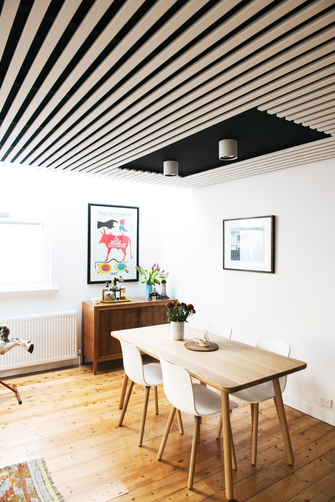 This is an example of a mid-sized scandinavian open plan dining in Melbourne with white walls and light hardwood floors.
