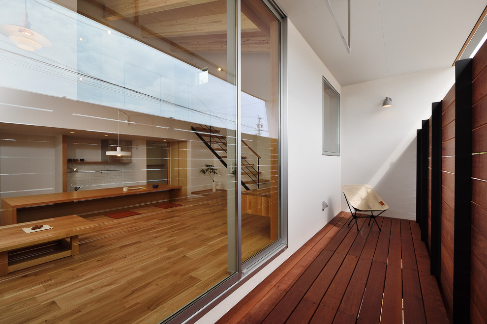 Foto på en liten minimalistisk balkong insynsskydd, med takförlängning och räcke i trä