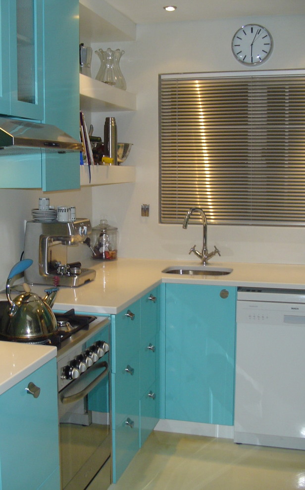 This is an example of a small contemporary u-shaped separate kitchen in Other with an undermount sink, flat-panel cabinets, turquoise cabinets, quartz benchtops, white splashback, glass sheet splashback, stainless steel appliances and concrete floors.