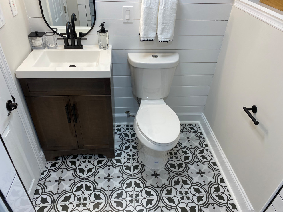 This is an example of a small country 3/4 bathroom in New York with an open shower, a one-piece toilet, black and white tile, porcelain tile, beige walls, porcelain floors, quartzite benchtops, multi-coloured floor, a shower curtain, white benchtops, a shower seat, a single vanity and a freestanding vanity.