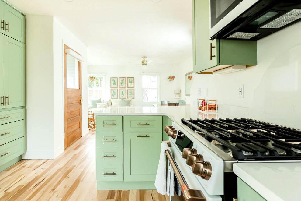 Foto på ett litet vintage vit kök, med en rustik diskho, skåp i shakerstil, gröna skåp, bänkskiva i kvartsit, vitt stänkskydd, stänkskydd i keramik, vita vitvaror, mellanmörkt trägolv och beiget golv