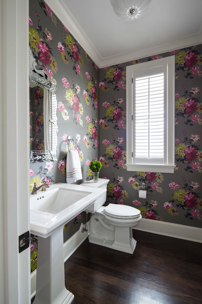 This is an example of a small transitional powder room in Minneapolis with multi-coloured walls, dark hardwood floors, a one-piece toilet, a pedestal sink and brown floor.