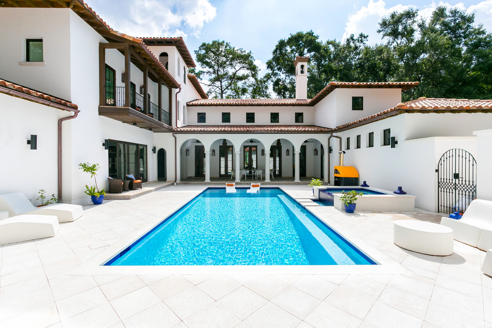 This is an example of a large mediterranean courtyard rectangular lap pool in Charleston with a hot tub and concrete pavers.