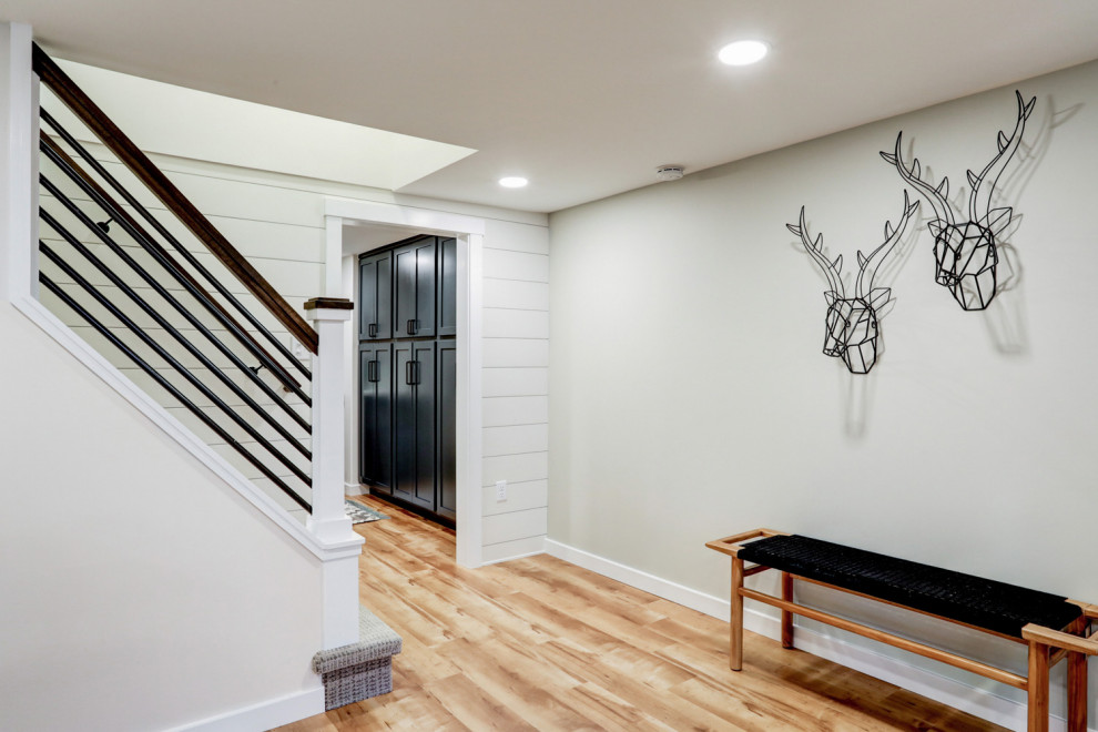This is an example of a large transitional look-out basement in Other with white walls, vinyl floors, brown floor and planked wall panelling.