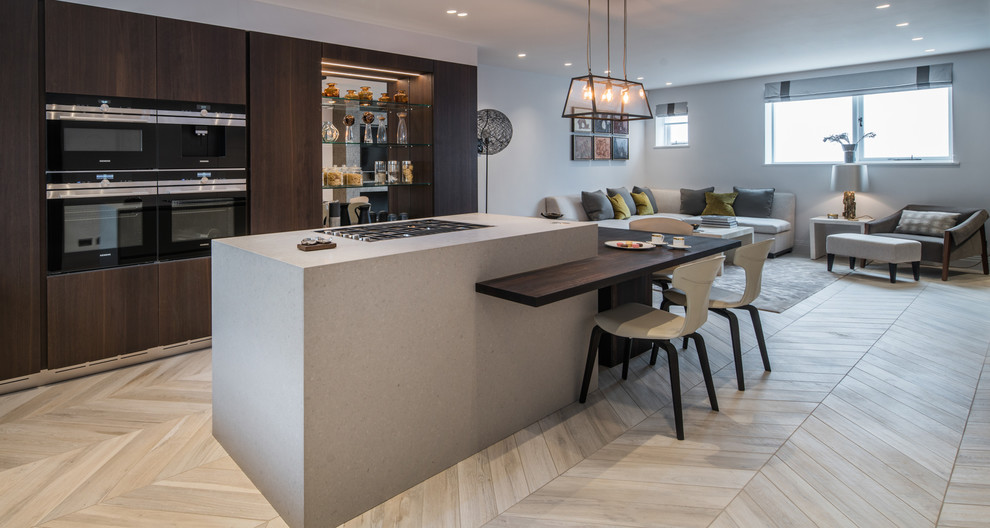 Inspiration for a mid-sized contemporary open plan kitchen with flat-panel cabinets, dark wood cabinets, concrete benchtops, light hardwood floors, with island and white floor.