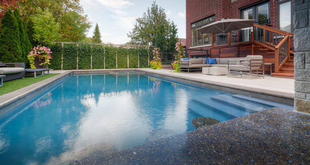 Inspiration for a large modern backyard rectangular pool in Other with a water feature and natural stone pavers.