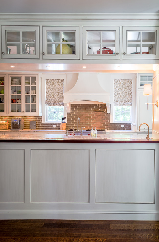 Mid-sized transitional galley dark wood floor eat-in kitchen photo in Bridgeport with a farmhouse sink, recessed-panel cabinets, gray cabinets, granite countertops, gray backsplash, subway tile backsplash, stainless steel appliances and two islands