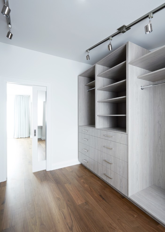 Design ideas for a large transitional gender-neutral walk-in wardrobe in Toronto with flat-panel cabinets, medium wood cabinets and medium hardwood floors.