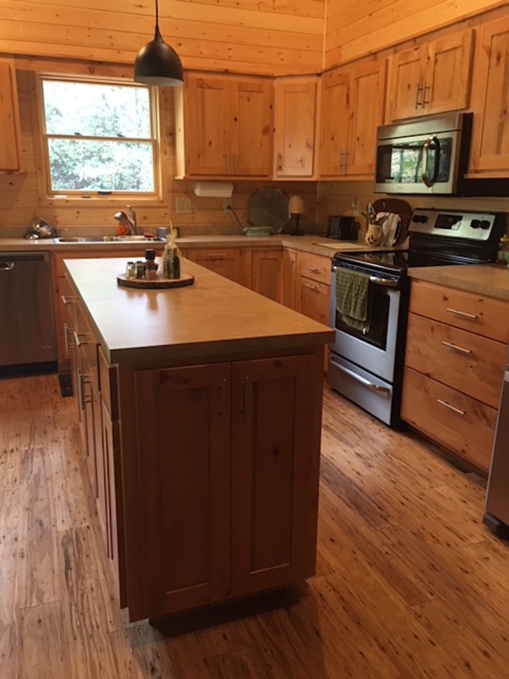 Kitchen - large rustic l-shaped medium tone wood floor and brown floor kitchen idea with a double-bowl sink, shaker cabinets, light wood cabinets, solid surface countertops, brown backsplash, wood backsplash and stainless steel appliances