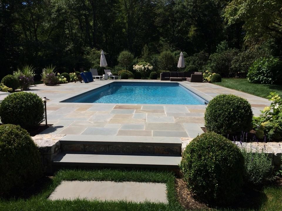Design ideas for a mid-sized contemporary backyard rectangular lap pool in New York with natural stone pavers.