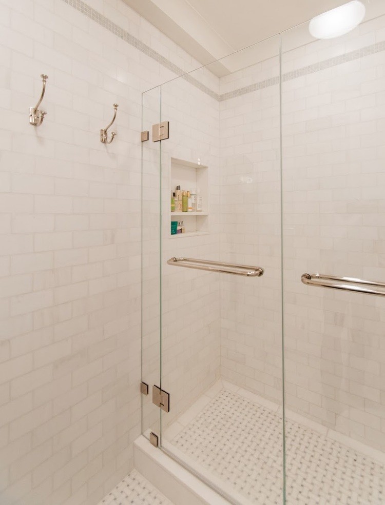 This is an example of a mid-sized modern master bathroom in New York with an alcove shower, white tile, white walls and ceramic floors.