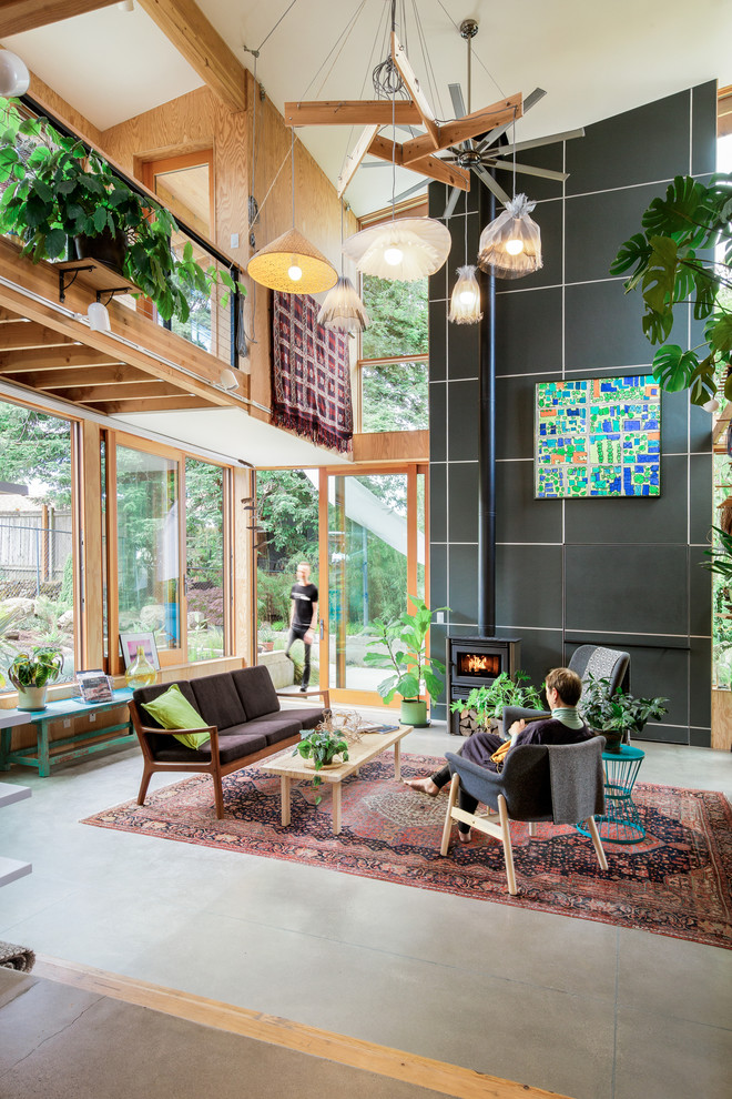 Design ideas for a contemporary loft-style living room in Portland with concrete floors, a wood stove and no tv.