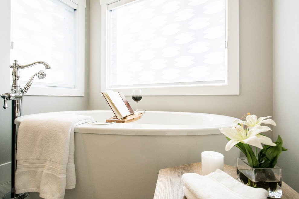 Example of a mid-sized transitional master gray tile and porcelain tile porcelain tile and gray floor freestanding bathtub design in Calgary with recessed-panel cabinets, black cabinets, gray walls, an undermount sink, quartz countertops and a hinged shower door