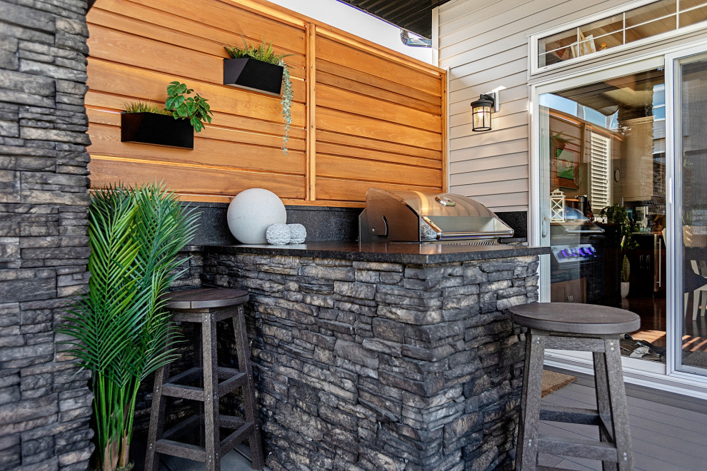 Foto de terraza planta baja rústica de tamaño medio en patio trasero y anexo de casas con chimenea y barandilla de vidrio