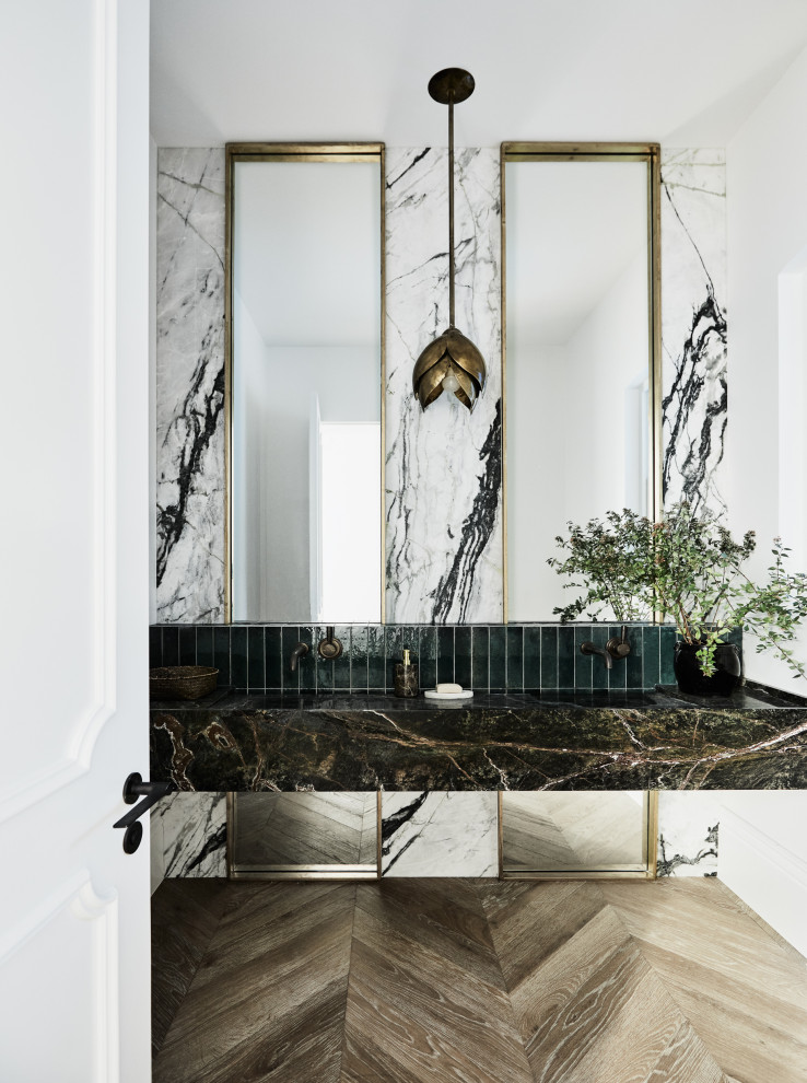 Immagine di un grande bagno di servizio tradizionale con piastrelle verdi, piastrelle di marmo, pareti bianche, pavimento in legno massello medio, lavabo integrato, top in marmo, pavimento marrone e top verde