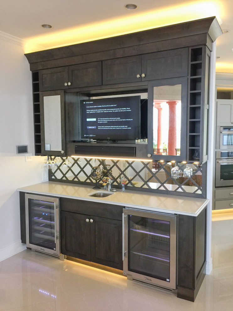 This is an example of a mid-sized contemporary single-wall home bar in Miami with an undermount sink, shaker cabinets, grey cabinets, quartz benchtops, mirror splashback and porcelain floors.
