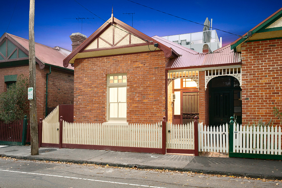 This is an example of a large traditional three-storey brick townhouse exterior in Melbourne with a gable roof.