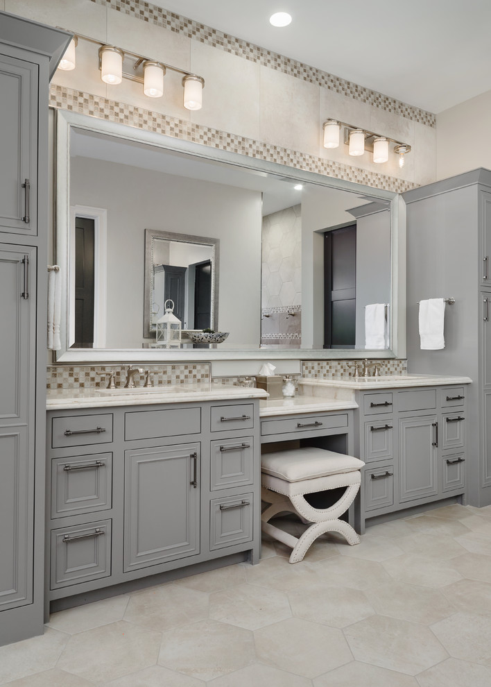 This is an example of a mid-sized eclectic master bathroom in Phoenix with shaker cabinets, grey cabinets, a freestanding tub, an open shower, a two-piece toilet, gray tile, porcelain tile, grey walls, porcelain floors, an undermount sink, solid surface benchtops, beige floor and an open shower.