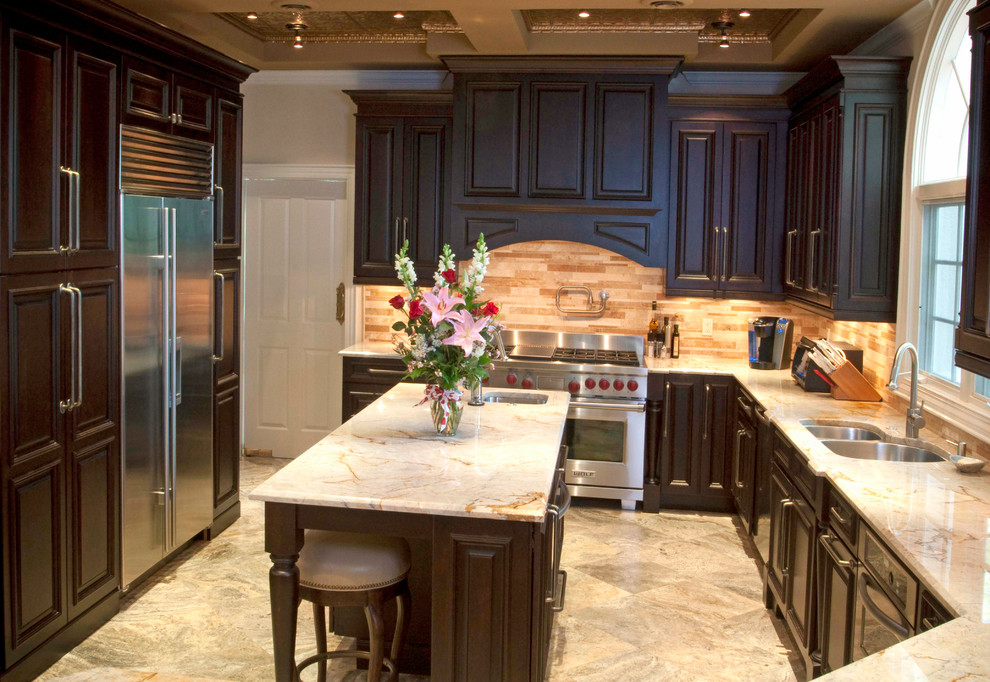 Photo of a mid-sized traditional u-shaped separate kitchen in Tampa with a double-bowl sink, raised-panel cabinets, dark wood cabinets, marble benchtops, beige splashback, stone tile splashback, stainless steel appliances, porcelain floors, with island and multi-coloured floor.