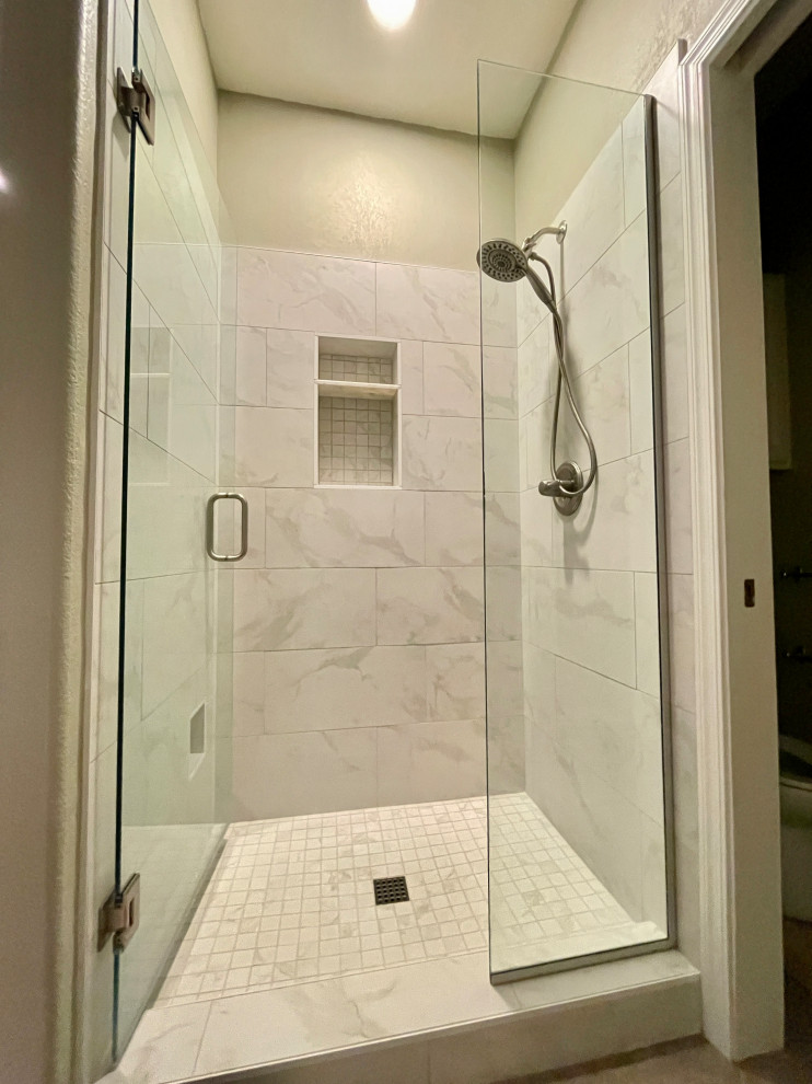 This is an example of a mid-sized transitional master bathroom in Phoenix with an alcove shower, white tile, travertine, beige walls, travertine floors, beige floor, a hinged shower door and a niche.