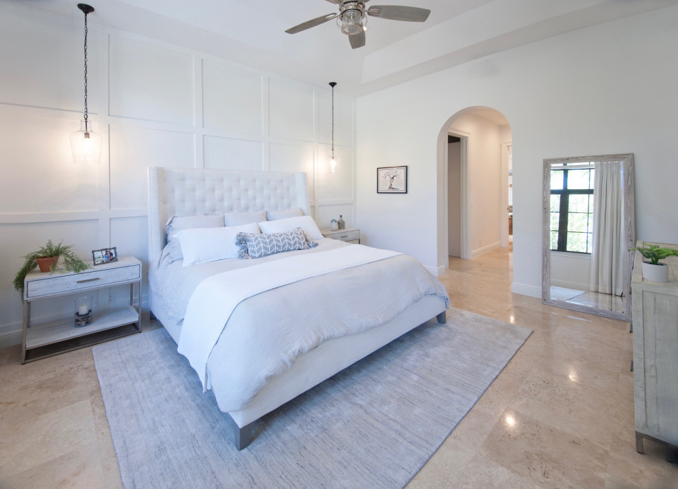 Mid-sized beach style master bedroom in Miami with white walls, travertine floors, beige floor and decorative wall panelling.